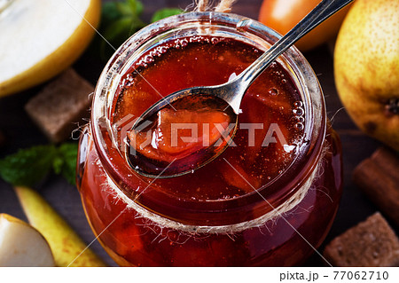 Homemade pear jam in a jar and fresh pears on a wooden background. Homemade pear jam in a jar and fresh pears on a wooden background. 77062710