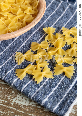 uncooked mini farfalle pasta on rustic background 77065106