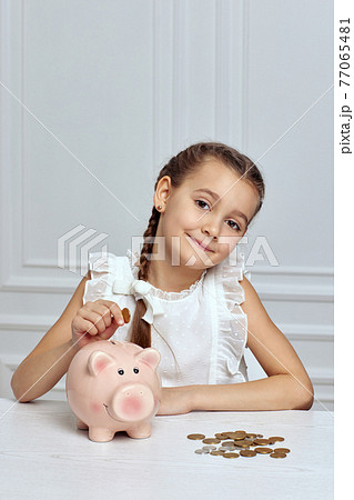 Little child girl with piggy bank at home Little child girl with piggy bank at home 77065481