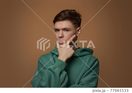handsome guy touch his chin by hand thinking handsome guy touch his chin by hand thinking 77065533