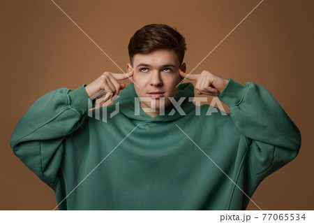 young handsome guy touch his chin by hand thinking young handsome guy touch his chin by hand thinking 77065534