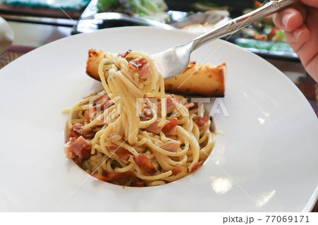spaghetti or spaghetti carbonara with bread 77069171
