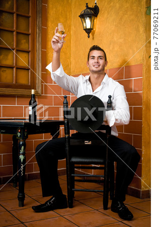 Flamenco dancer from Seville in Spain drinking a wine before dancing in a typical Spanish venue Flamenco dancer from Seville in Spain drinking a wine before dancing in a typical Spanish venue 77069211