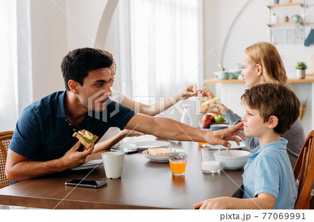Young family eating breakfast Young family eating breakfast 77069991