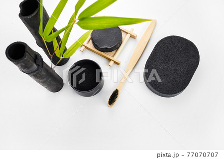 Skin and tooth cleansing and detox. Bamboo charcoal powder cosmetics on white background Skin and tooth cleansing and detox. Bamboo charcoal powder cosmetics on white background 77070707