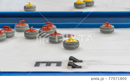 equipment for the game of curling. selective focus. granite stone and hack on ice.  77071800