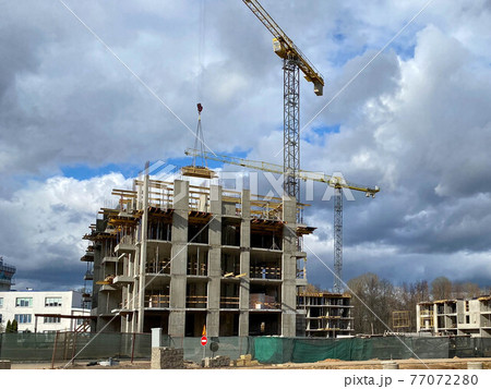 Construction of new high-rise building in the city two construction cranes in a construction site 77072280