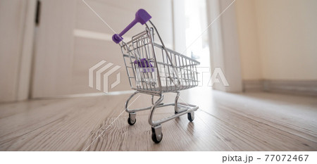 Grocery cart at the open door. Delivery of products. Mini trolley for contactless delivery. Grocery cart at the open door. Delivery of products. Mini trolley for contactless delivery. 77072467