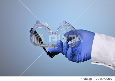 Doctor Hand Gives Eye Protective Plastic Glass Mask 77075505