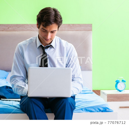 Businessman working in the hotel room 77076712