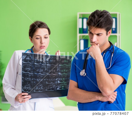 Woman and man gynecologists discussing medical case at the clini 77078407