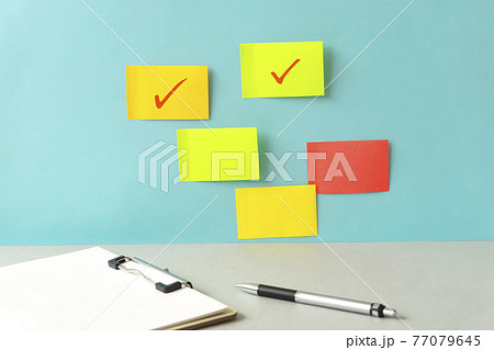 壁に貼られた付箋とチェックの印。仕事の進行状況、スケジュール、学習、業務状況など 壁に貼られた付箋とチェックの印。仕事の進行状況、スケジュール、学習、業務状況など 77079645