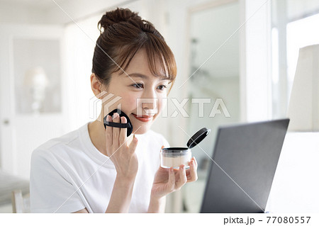 メイクをするきれいな若い女性 77080557
