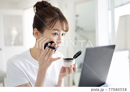 メイクをするきれいな若い女性 77080558