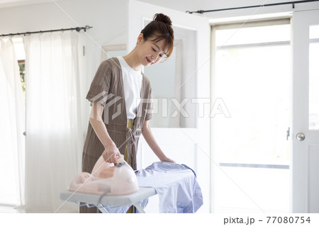 家でアイロンをかける若い女性 家でアイロンをかける若い女性 77080754