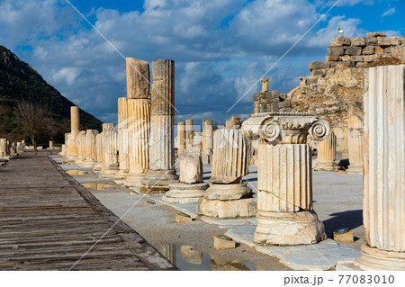 State Agora columns in ancient Ephesus with Odeon ruins in background 77083010