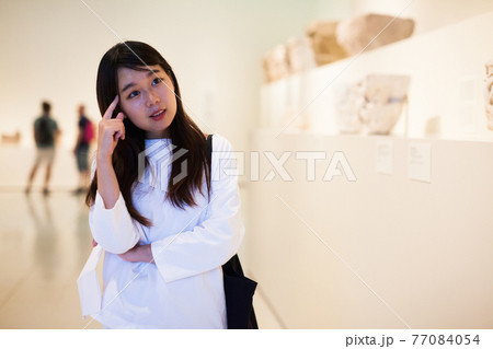 Thoughtful chinese woman in historical museum looking at art object Thoughtful chinese woman in historical museum looking at art object 77084054