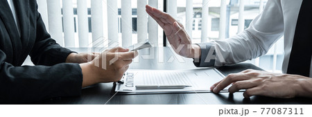 Anti bribery and corruption concept, Business man refusing and don't receive money banknote in envelope offer from business people to accept agreement contract of investment deal Anti bribery and corruption concept, Business man refusing and don't receive money banknote in envelope offer from business people to accept agreement contract of investment deal 77087311