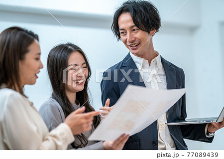 住宅の間取り図面を見ながら打ち合わせをする男女三人 建築士 住宅の間取り図面を見ながら打ち合わせをする男女三人 建築士 77089439