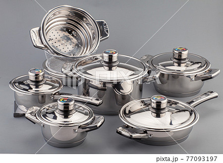 Stainless steel cookware, pots and pans on gray background. Kitchenware set utensils 77093197