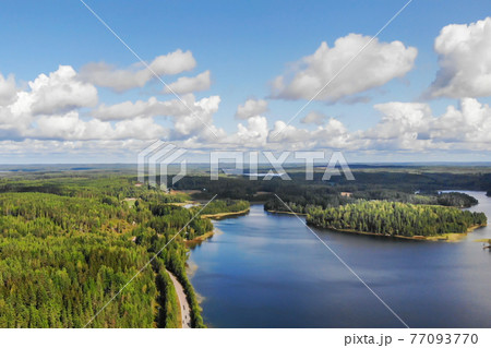 Aerial view of lake with island, road and forest on a summer sunny day in Finland. Drone photography 77093770