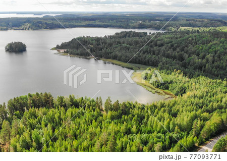 Aerial view of lake with island, road and forest on a summer sunny day in Finland. Drone photography 77093771