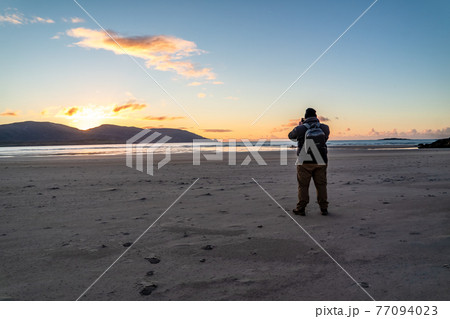 Man standing at Kiltoorish bay beach between Ardara and Portnoo in Donegal - Ireland. 77094023