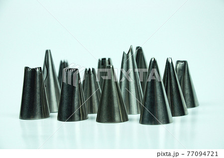 Sets of cream piping nozzles made from stainless steel isolated on white background. It is used to decorate cakes using cream. Sets of cream piping nozzles made from stainless steel isolated on white background. It is used to decorate cakes using cream. 77094721