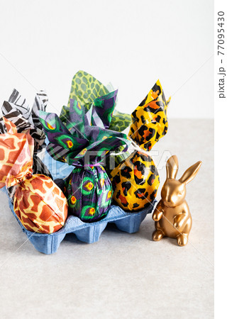 Easter eggs wrapped up in animal print paper 77095430