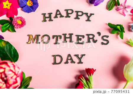 Happy Mothers Day letters with different spring flowers around them 77095431