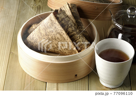 セイロ蒸しされた湯気立つ中華ちまきと急須とお茶 77096110