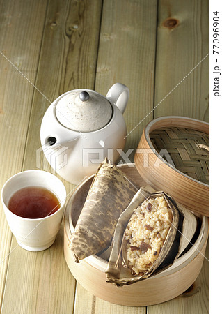 セイロ蒸しされて湯煙立つ中華ちまきと急須とお茶 77096904