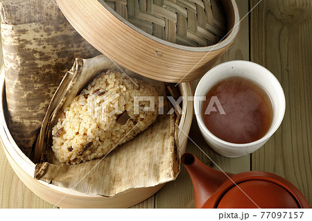 セイロ蒸しされた湯気立つ中華ちまきと急須とお茶（俯瞰） 77097157