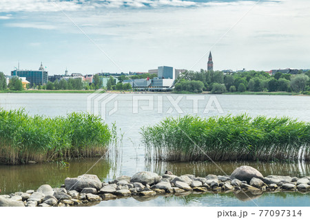Helsinki, Finland - June 12, 2019: Toolo bay in the City Park in Helsinki, Finlandia Hall congress and event venue can be seen across the water Helsinki, Finland - June 12, 2019: Toolo bay in the City Park in Helsinki, Finlandia Hall congress and event venue can be seen across the water 77097314