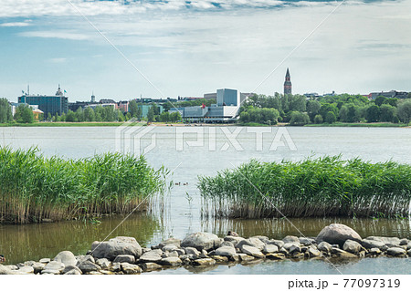 Helsinki, Finland - June 12, 2019: Toolo bay in the City Park in Helsinki, Finlandia Hall congress and event venue can be seen across the water 77097319