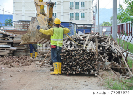 SEREMBAN, MALAYSIA -JANUARY 31, 2017: Construction workers working at the construction site during daytime. They are required to wear proper and suitable safety gear to ensure their safety.   77097974