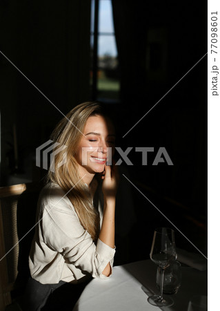 Caucasian woman sitting at cafe with wineglass in black background. 77098601