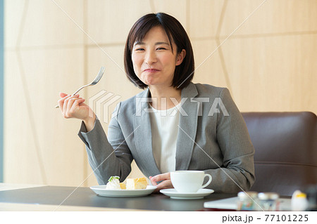 ケーキを食べる働く女性 ケーキを食べる働く女性 77101225