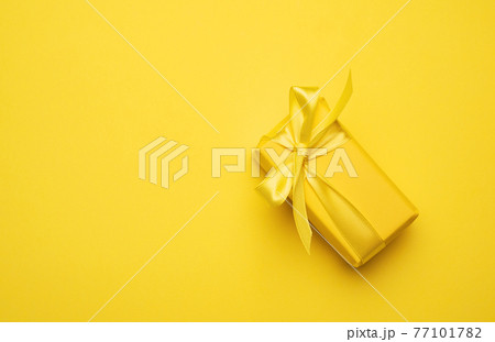 yellow rectangular box with a gift wrapped in yellow paper 77101782