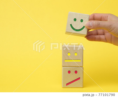 wooden blocks with different emotions from smile to sadness and a woman's hand. concept for assessing the quality of a product or service wooden blocks with different emotions from smile to sadness and a woman's hand. concept for assessing the quality of a product or service 77101790