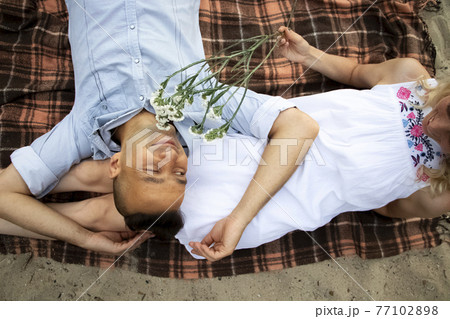 A young couple hugs passionately on the deserted sandy shore. Lifestyle of passionate newlyweds by the ocean. Love, passion and falling in love concept, A young couple hugs passionately on the deserted sandy shore. Lifestyle of passionate newlyweds by the ocean. Love, passion and falling in love concept, 77102898