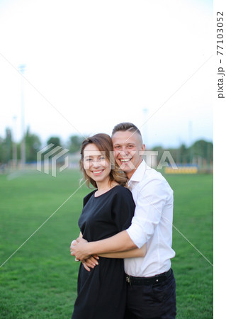 Young man hugging woman on football field. 77103052