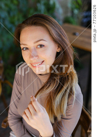 Young caucasian woman sitting on bench, portrait. 77103626