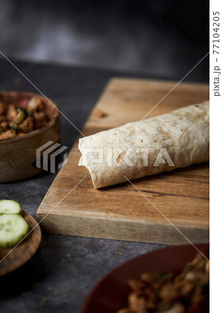 chicken and vegetables durum or burrito on a table chicken and vegetables durum or burrito on a table 77104205