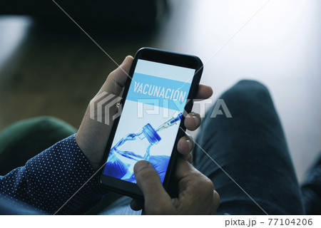 man and text vaccination in spanish in smartphone man and text vaccination in spanish in smartphone 77104206