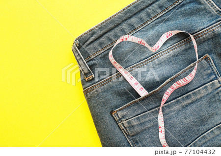 blue jeans with measure tape in pocket in form of a heart. concept of healthy lifestyle and diet with love to your body 77104432