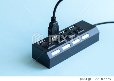 Black USB hub with usb cable plug on blue background Black USB hub with usb cable plug on blue background 77107775