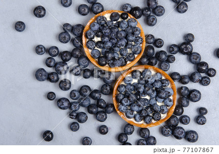 Delicious desserts of blueberry mini tart with fresh berries. Flat lay Delicious desserts of blueberry mini tart with fresh berries. Flat lay 77107867