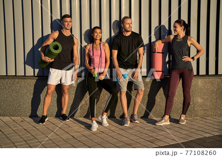 Happy two men and women going to train together in the city Happy two men and women going to train together in the city 77108260