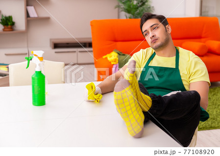 Young male contractor cleaning the house indoors 77108920